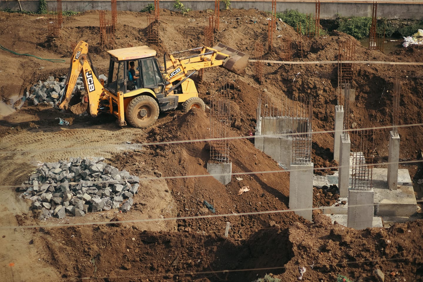Plate compactor compacting the aggregate base in lifts